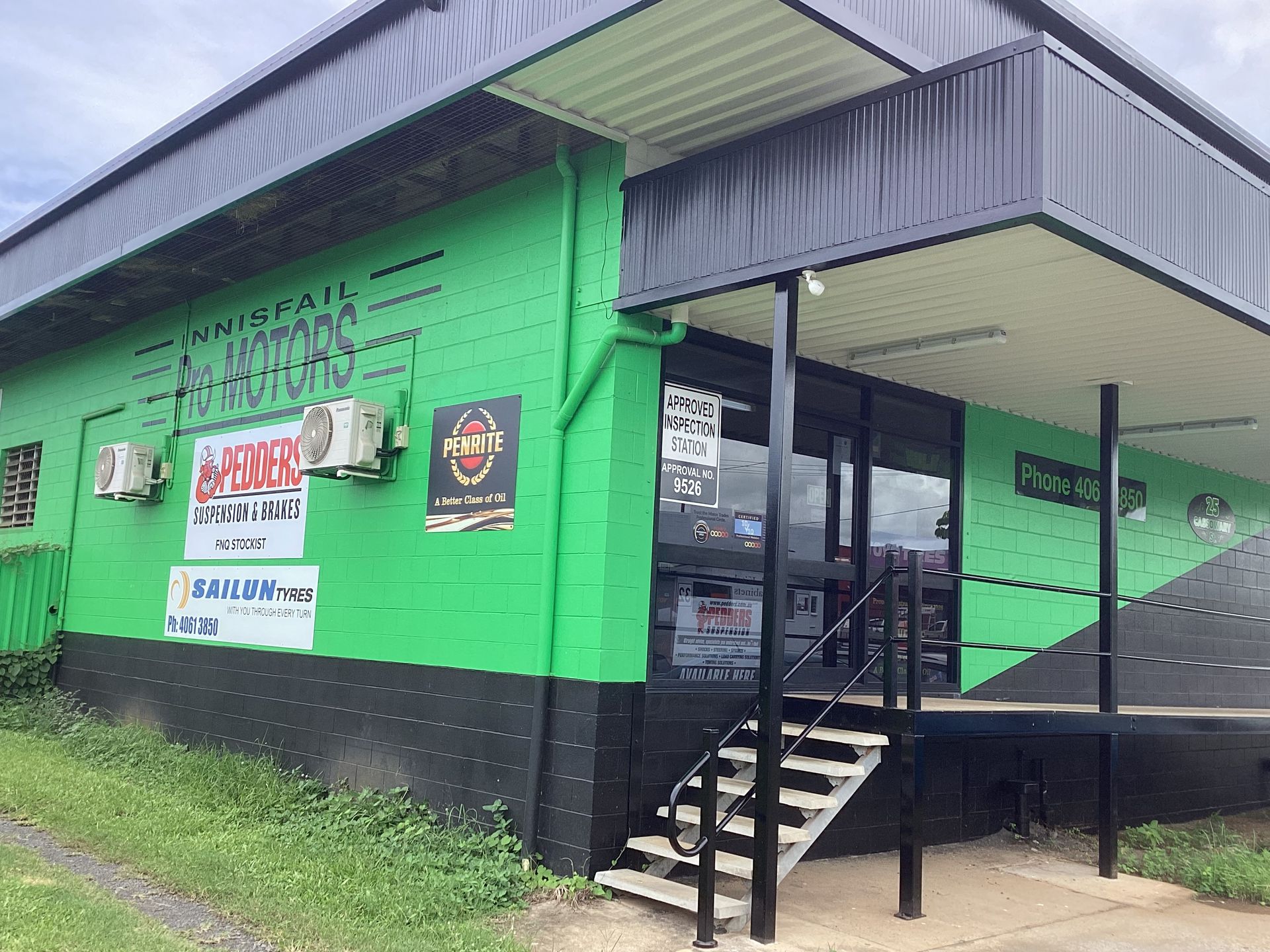 Cars in a garage, one red, one white. Car lifts and tools visible — Innisfail Pro Motors in Innisfail, QLD