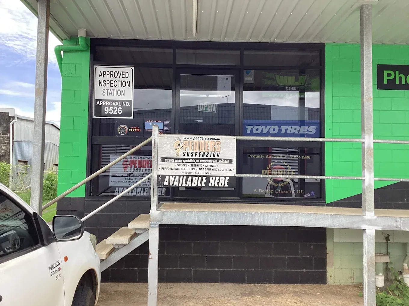 Green storefront with glass windows, advertising 