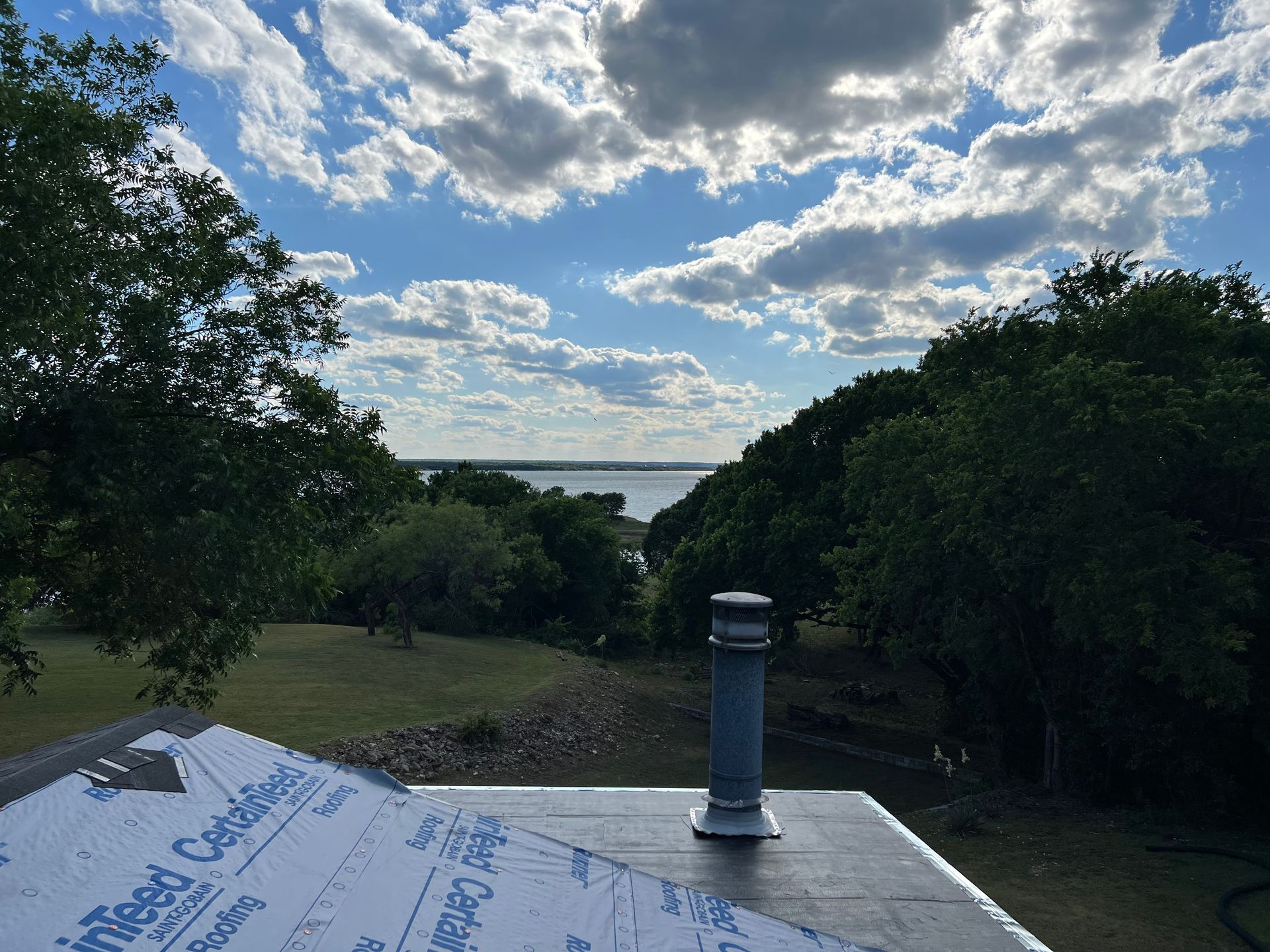 A roof with a view of a lake and trees