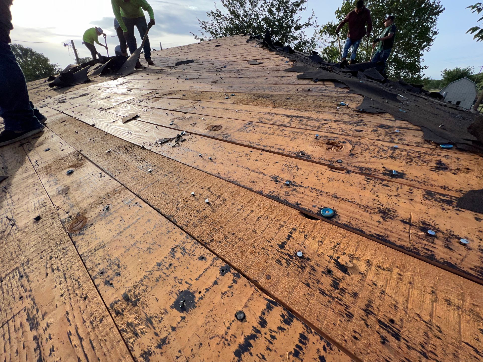 A group of people are working on a wooden roof.