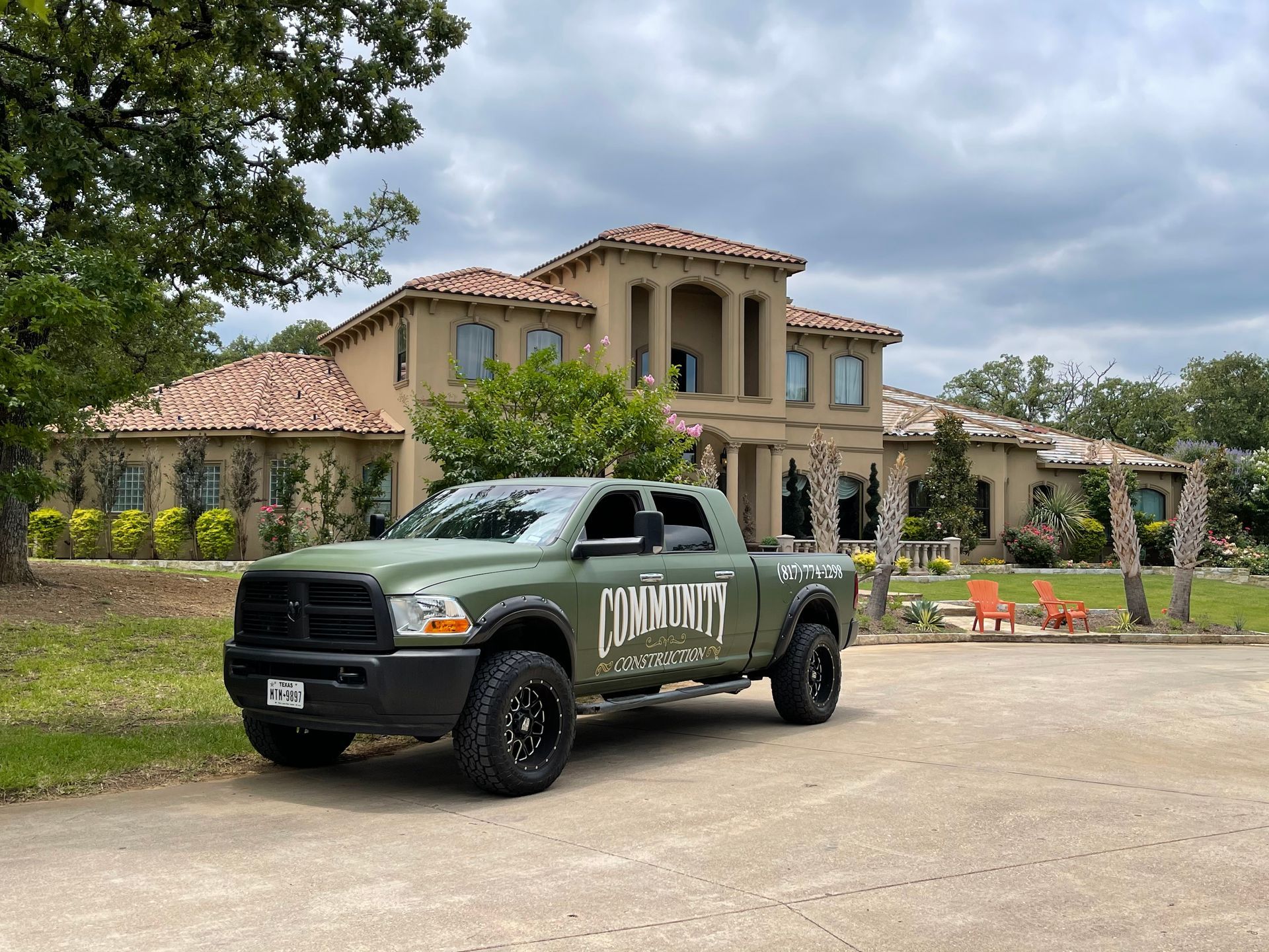 A truck is parked in front of a large house.