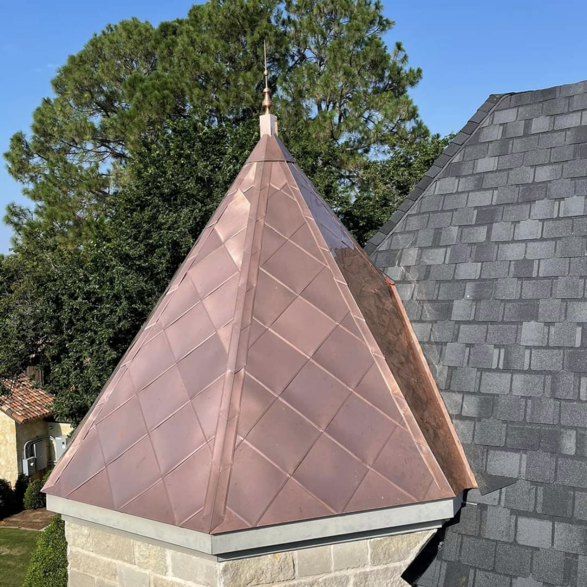 A copper pyramid on top of a brick chimney