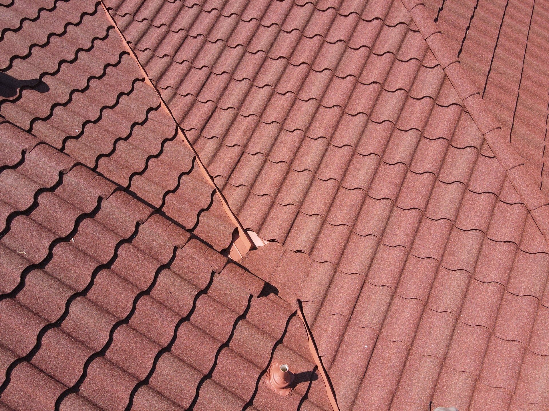 A close up of a roof with red tiles