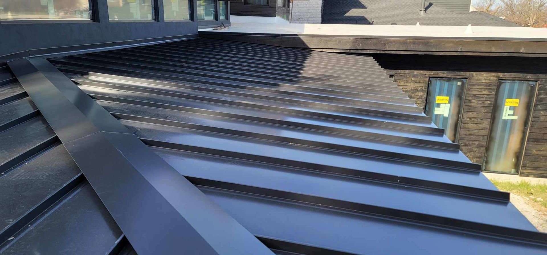 A close up of a black metal roof on a house.