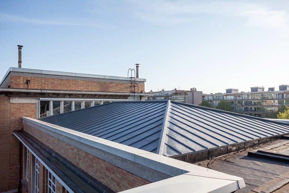 The roof of a brick building with a metal roof.