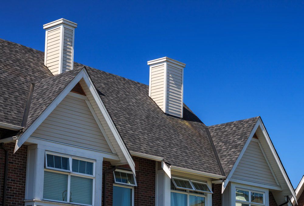A row of houses with chimneys on the roofs