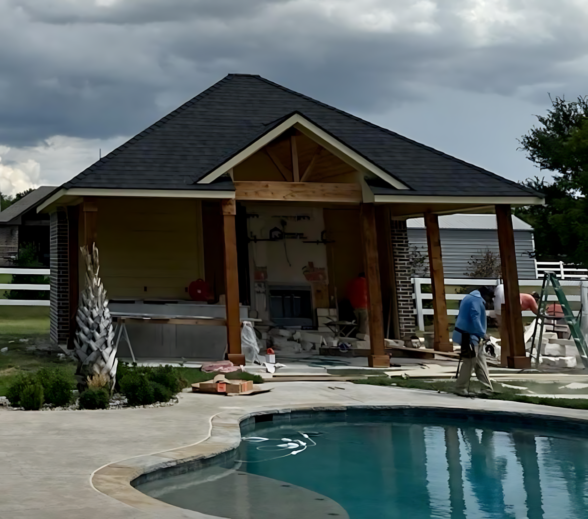 A man standing in front of a house next to a pool