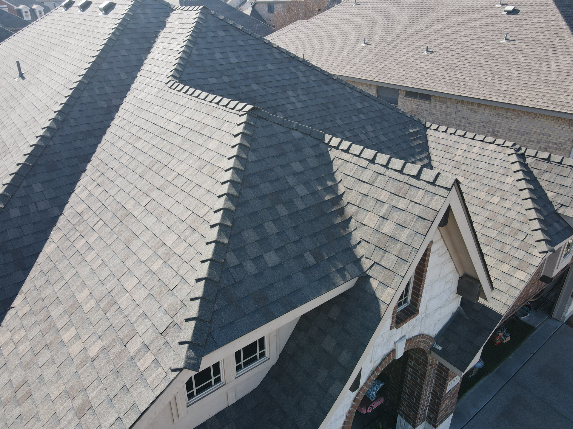 An aerial view of a house with a roof that has shingles on it