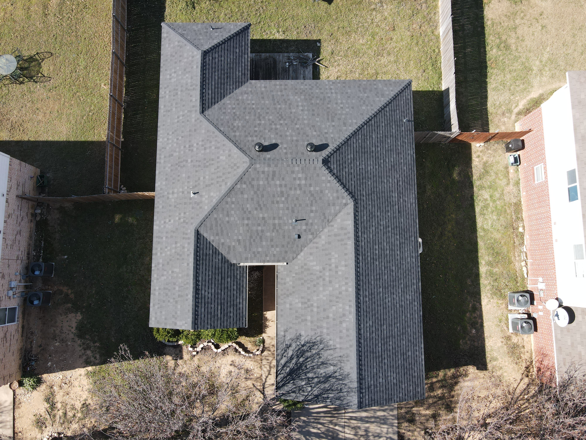 An aerial view of a house with a gray roof