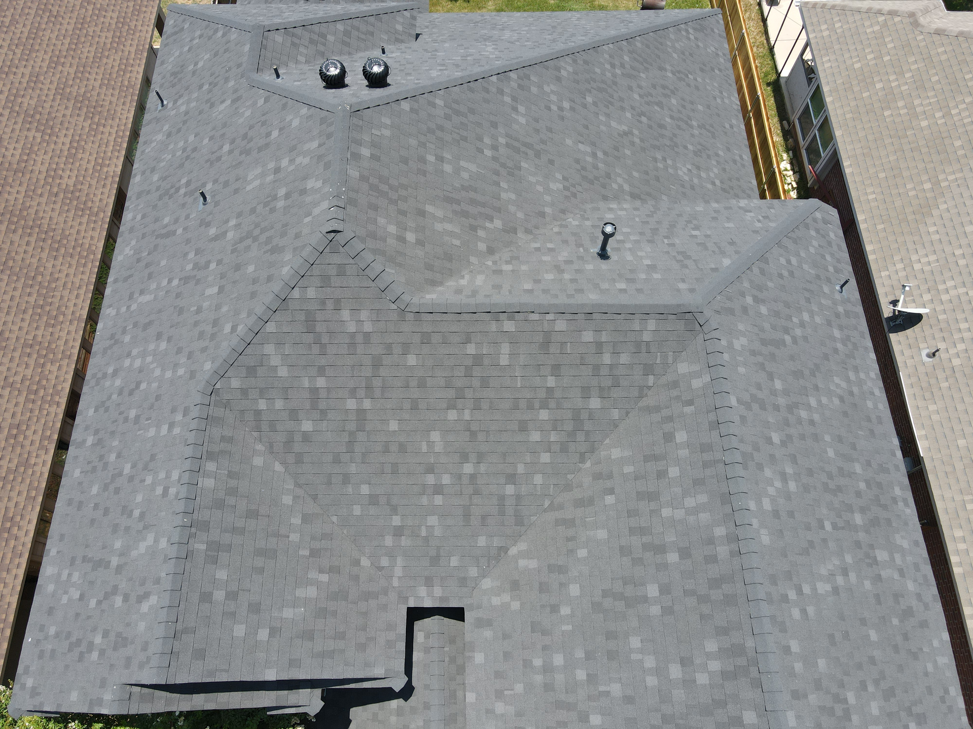 An aerial view of a house with a black roof.