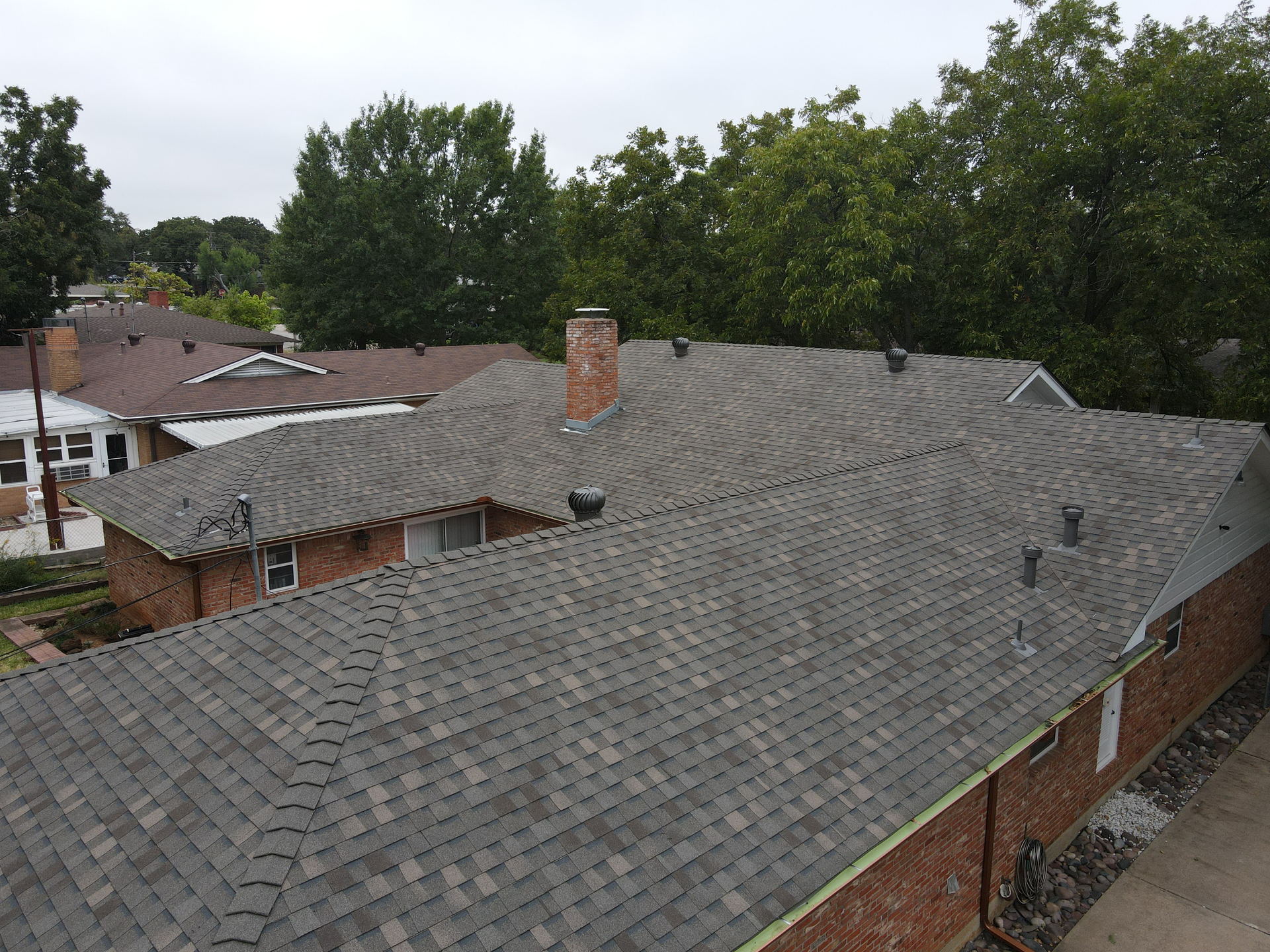 An aerial view of a house with a gray roof