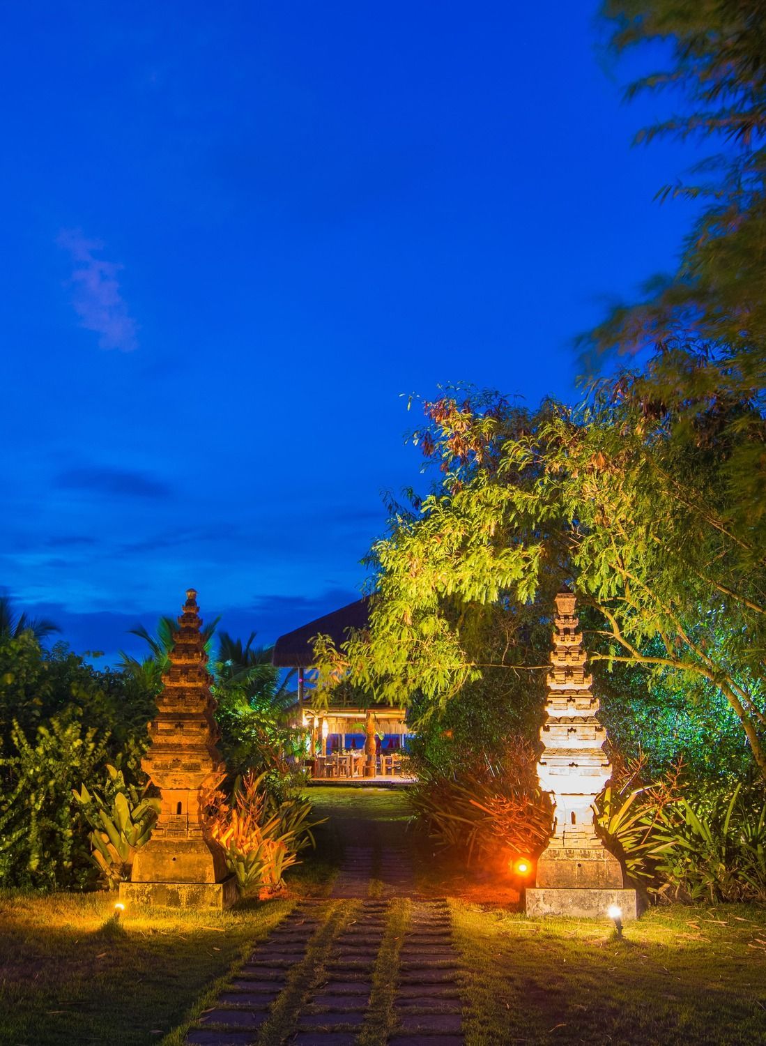 Um caminho que leva a uma casa é iluminado à noite.