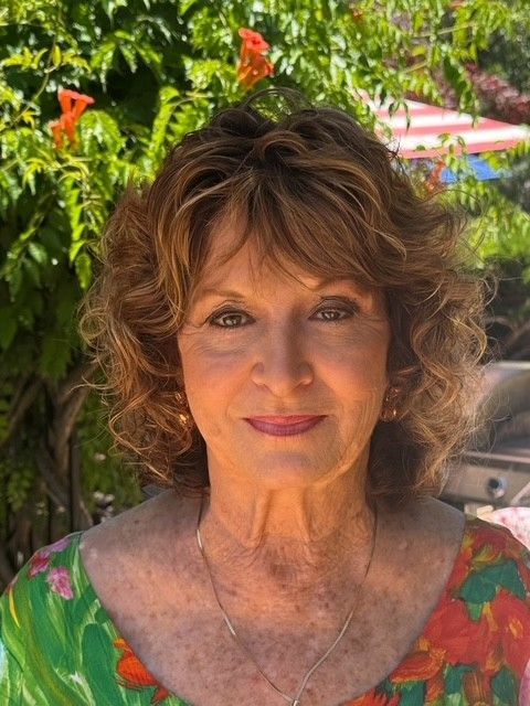 A close up of a woman 's face with trees in the background
