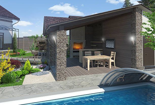 Luxury outdoor kitchen with stone pillars and patio cover.