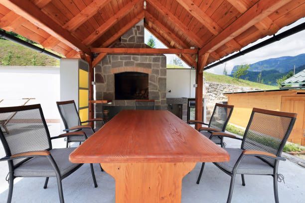 Rustic wood timber patio cover with stone fireplace.