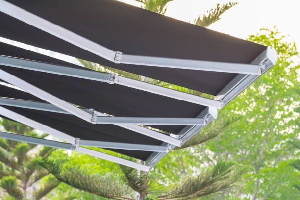 Black retractable motorized awning for backyard shade.