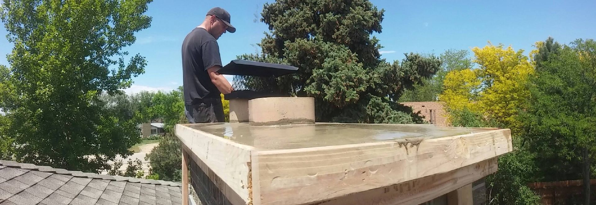 A man is standing on top of a wooden roof.