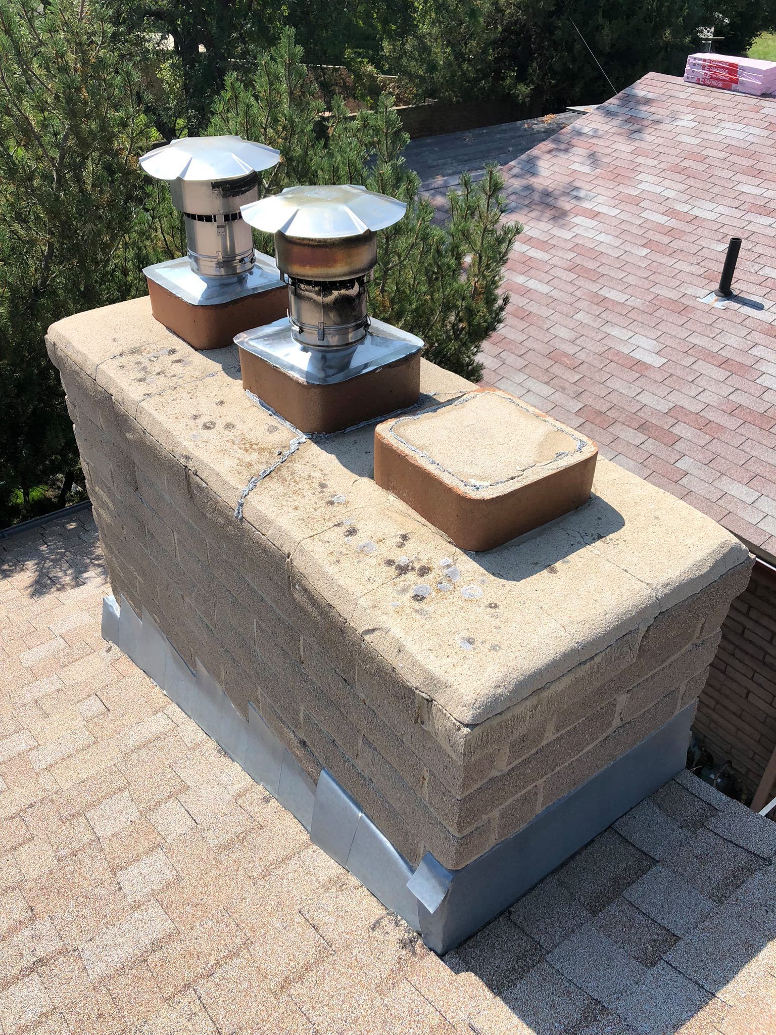 A chimney is sitting on top of a brick roof.