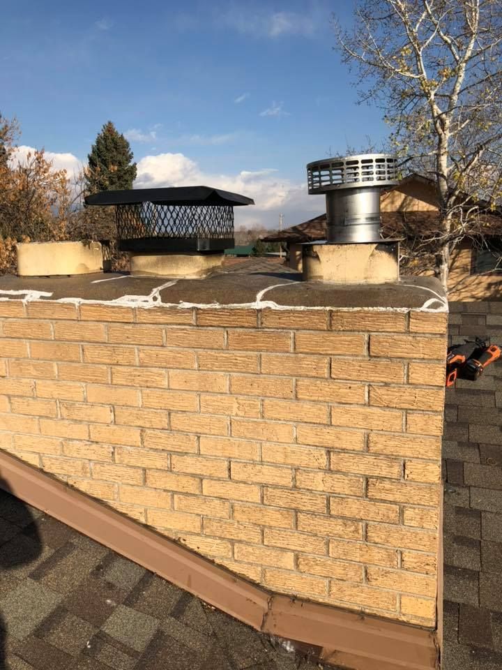 A brick chimney is sitting on top of a roof.