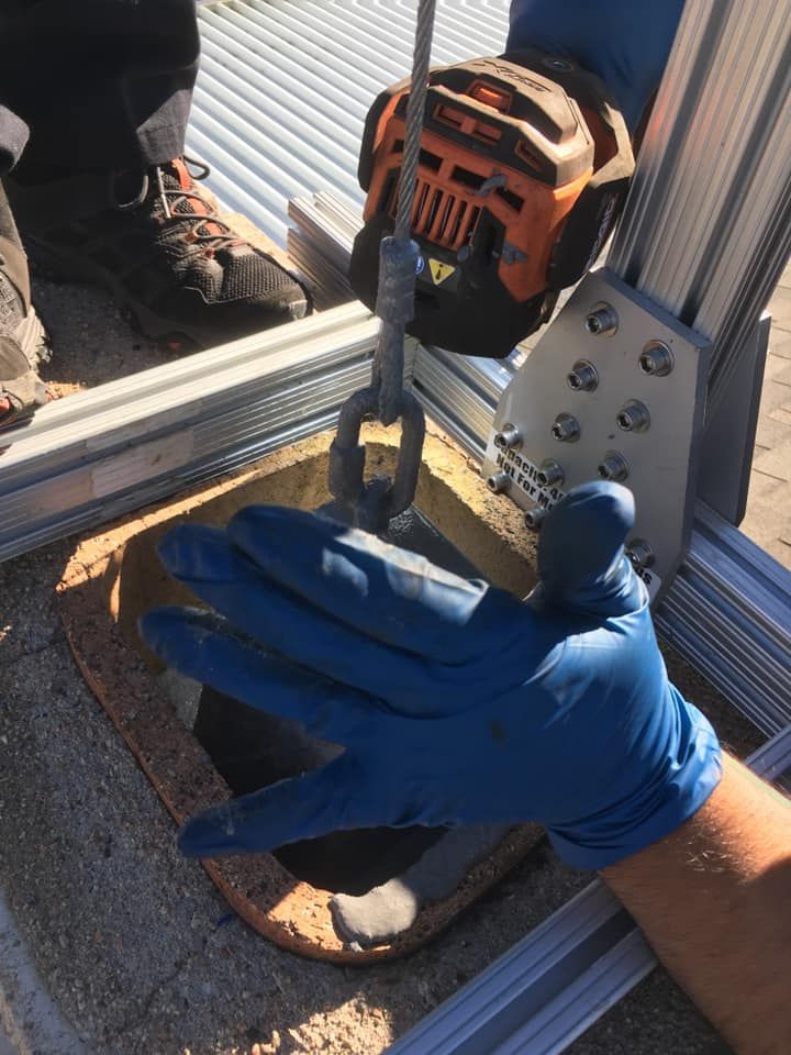 A person wearing blue gloves is working on a machine