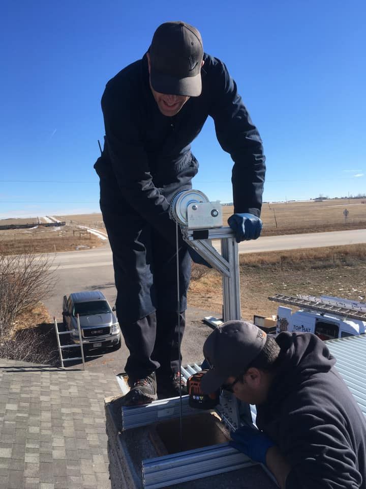Two men are working on a roof with a van in the background