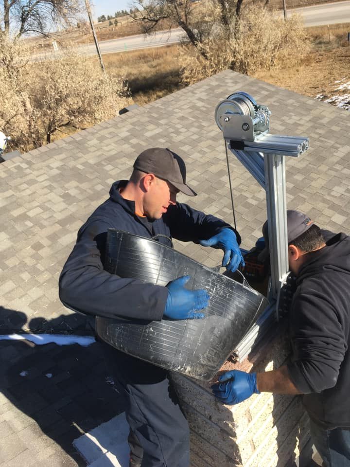 Two men are working on a roof and one of them is holding a piece of metal.