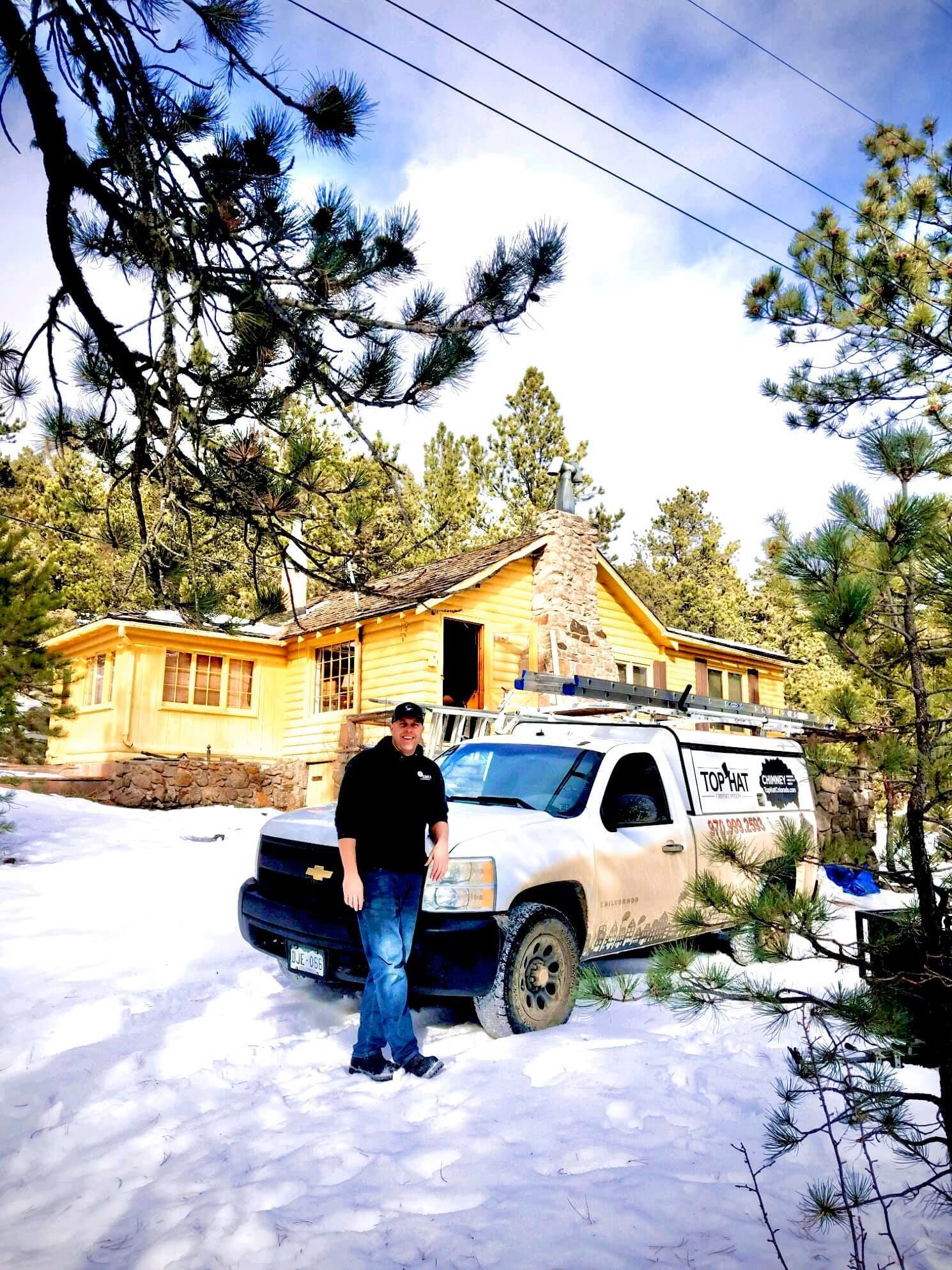 A man standing next to a truck in front of a house under construction