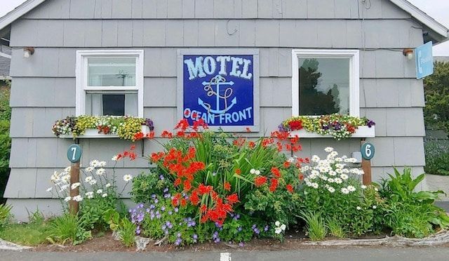 The front of a motel with flowers in front of it