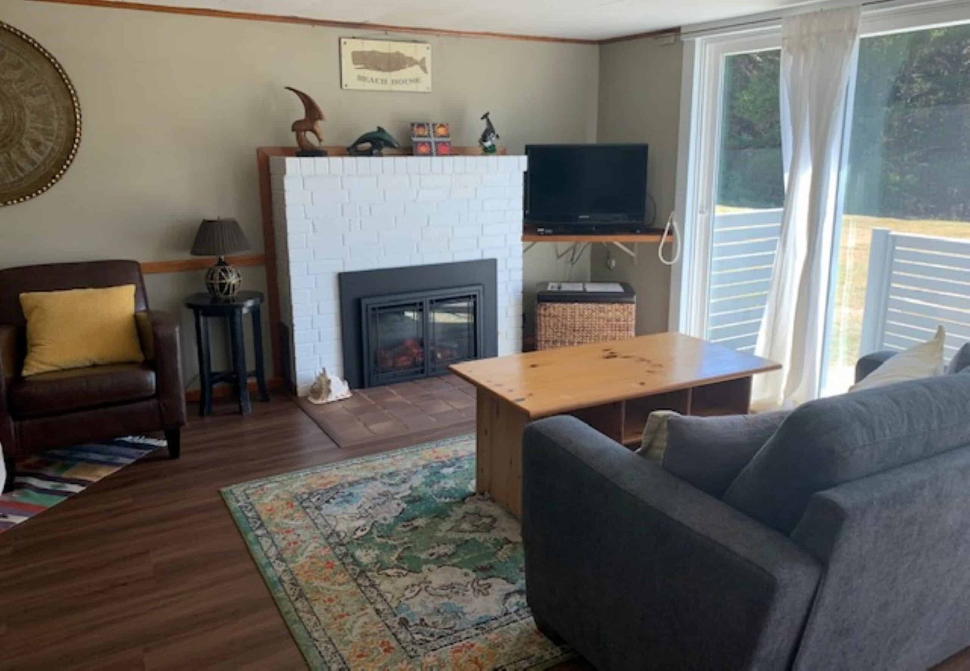A living room with a couch , chair , coffee table and fireplace.