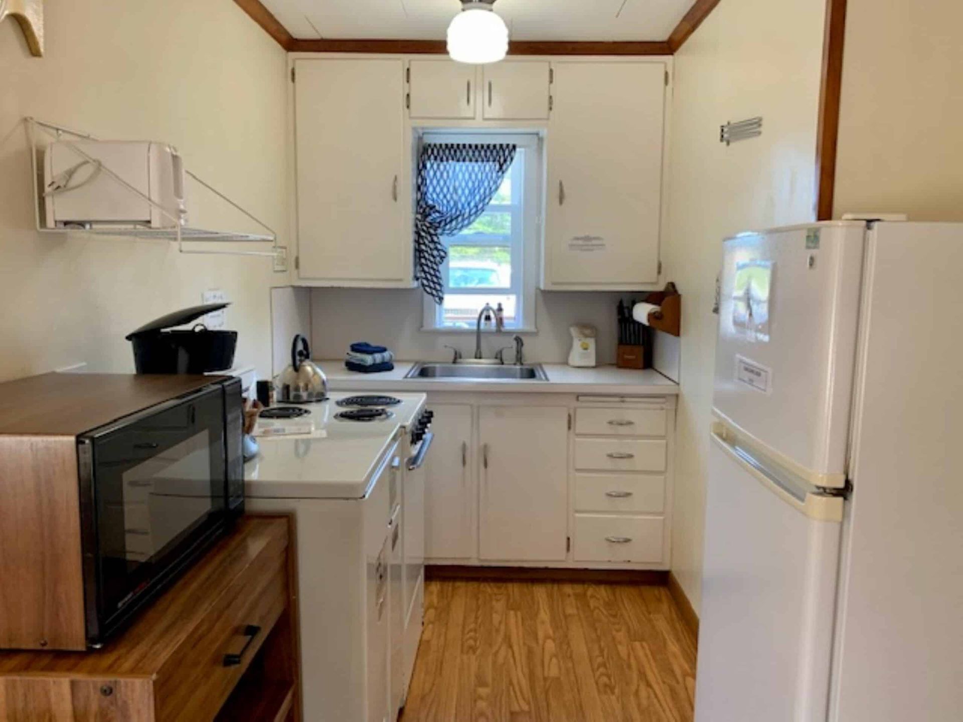 A small kitchen with white cabinets and a refrigerator