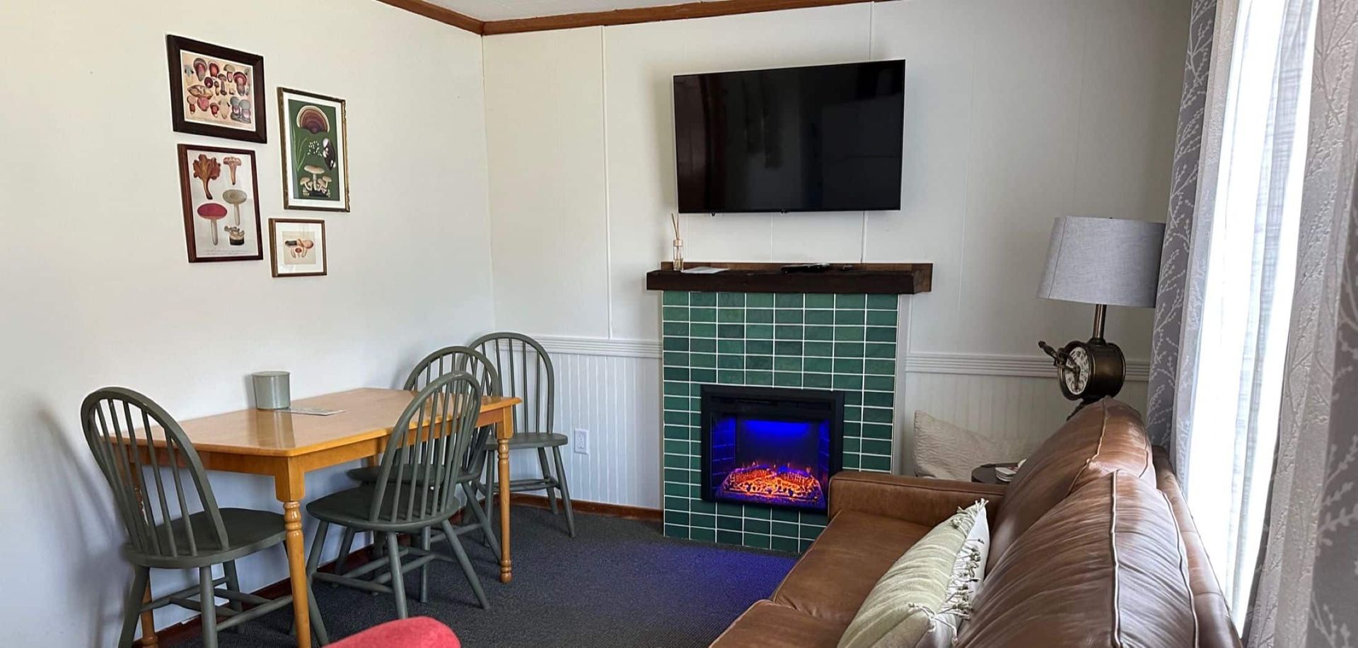 A living room with a fireplace , couch , table and chairs.