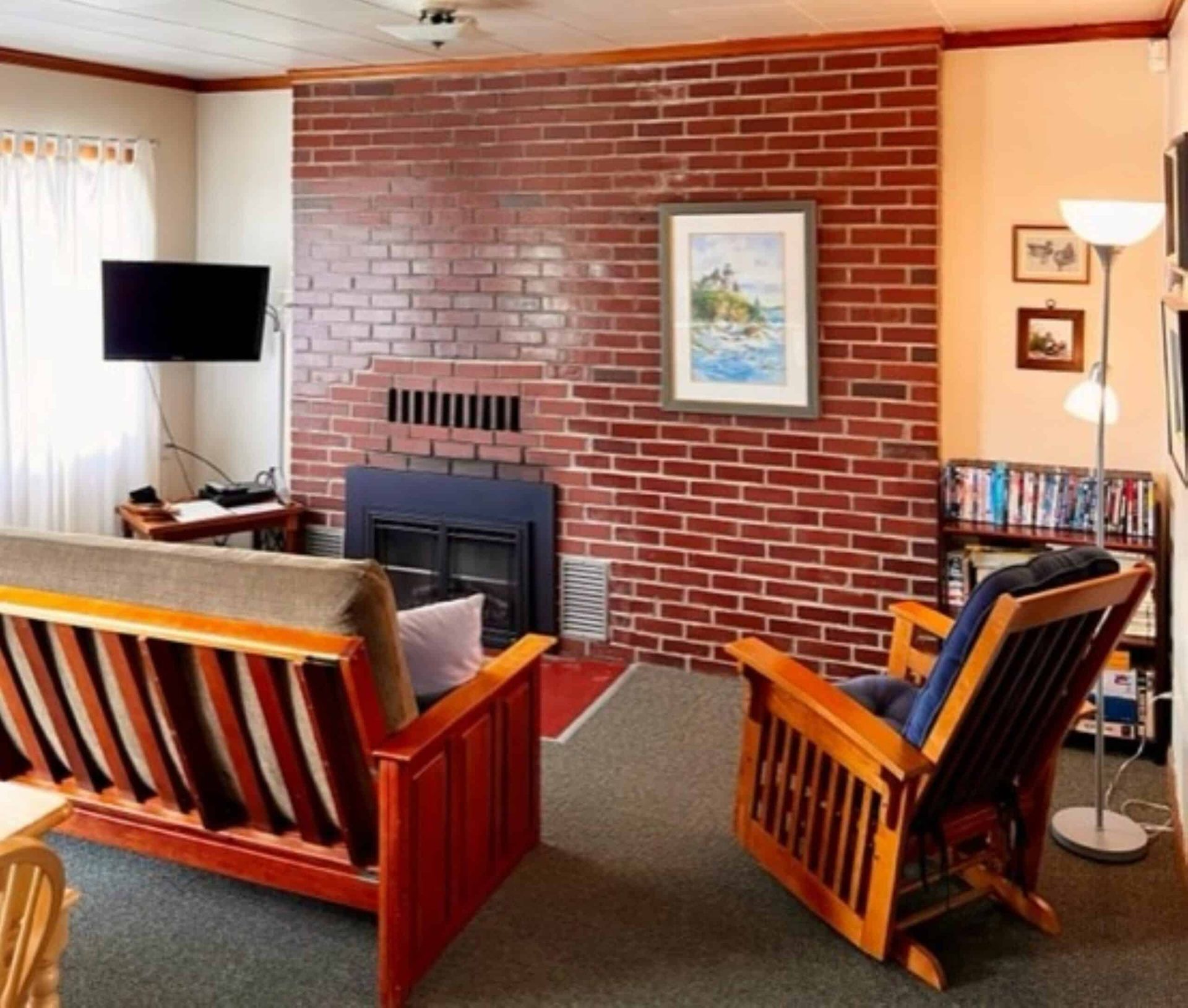 A living room with a brick wall and a fireplace