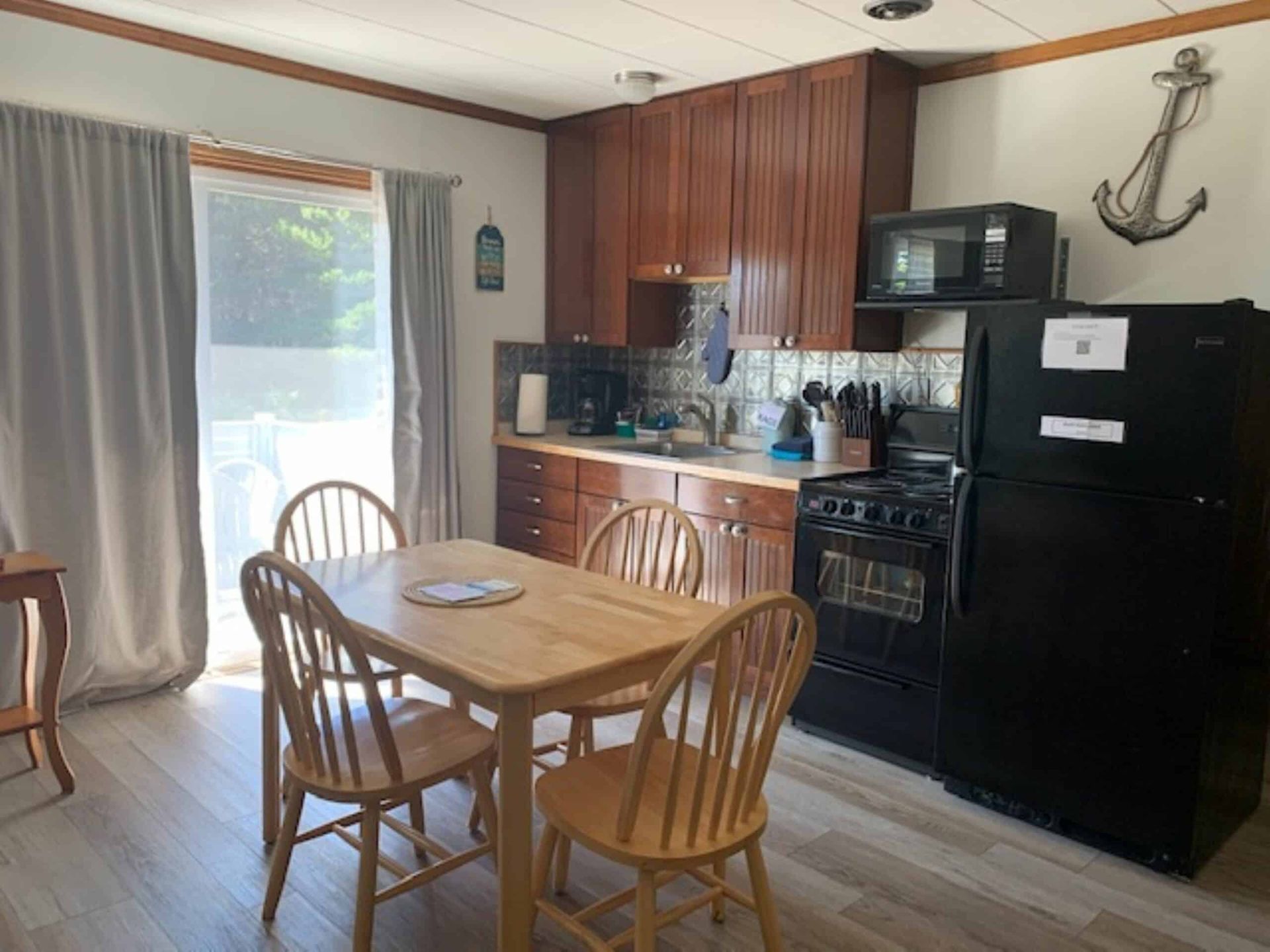 A kitchen with a table and chairs and a refrigerator.
