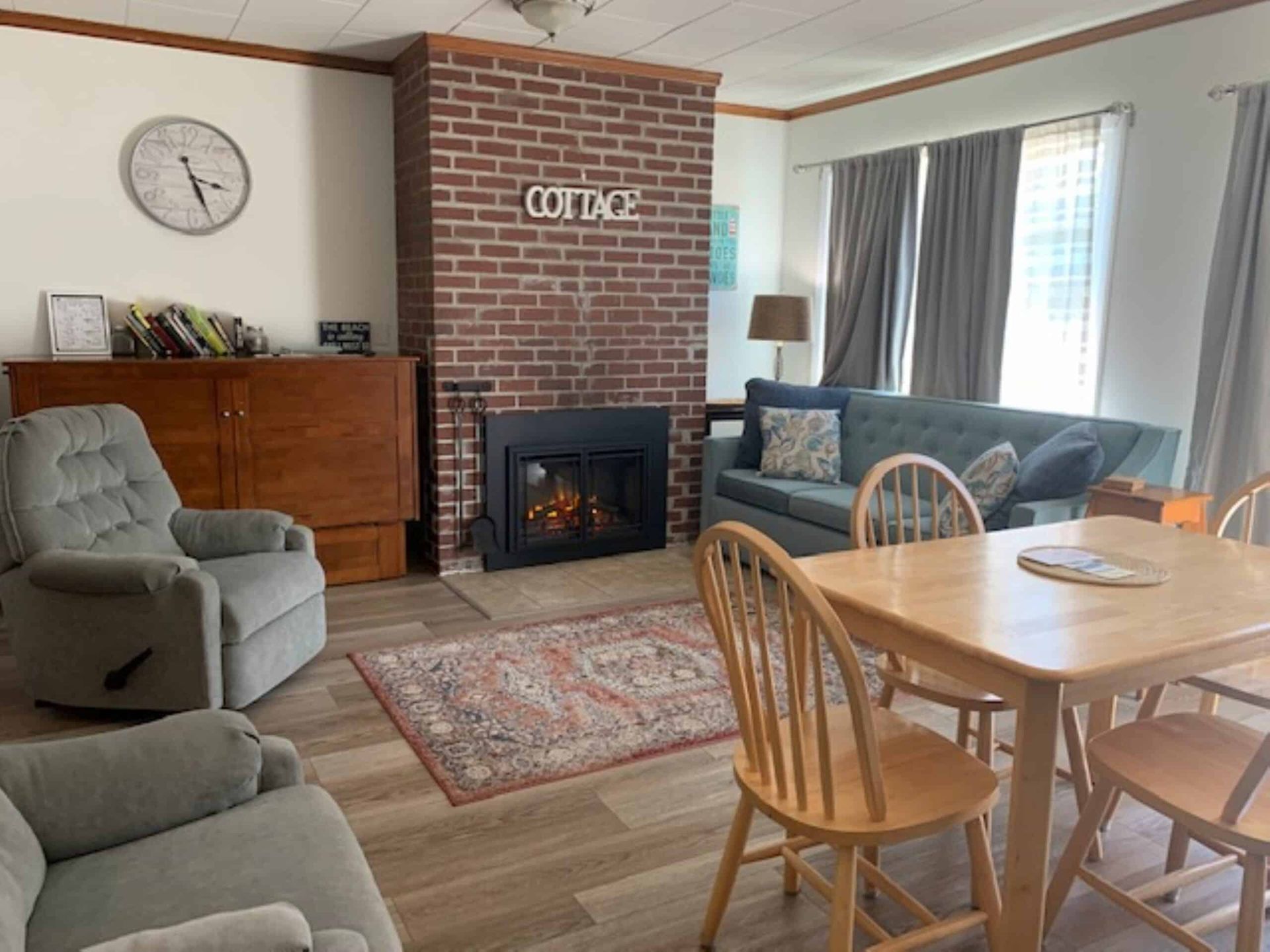 A living room with a couch , chairs , table and fireplace.