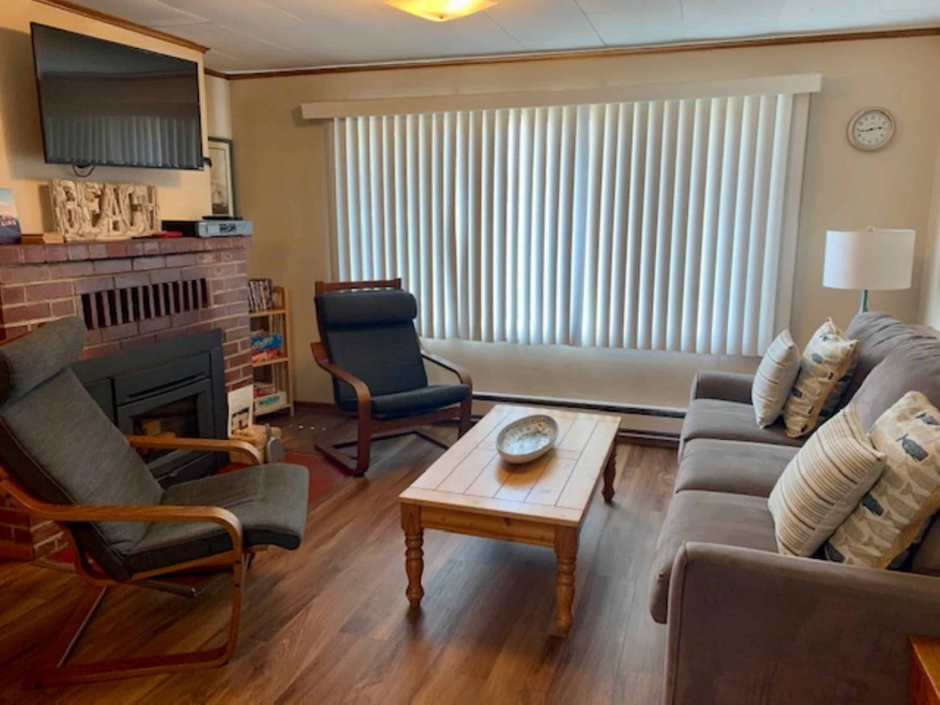 A living room with a couch , chair , coffee table and television.