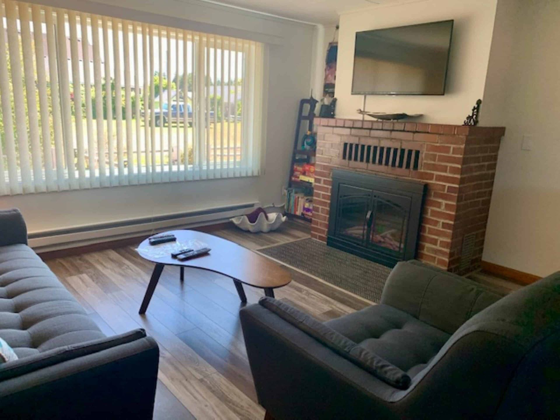 A living room with a fireplace , couch , chair and television.