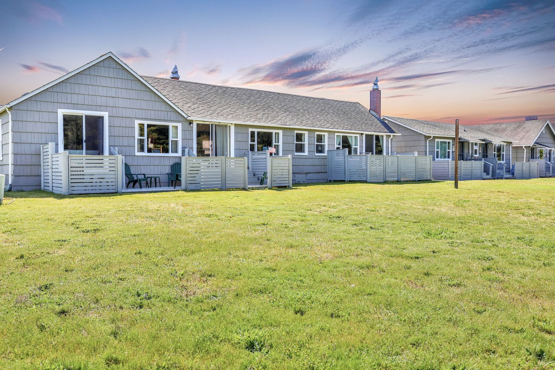 A row of houses are sitting on top of a lush green field.