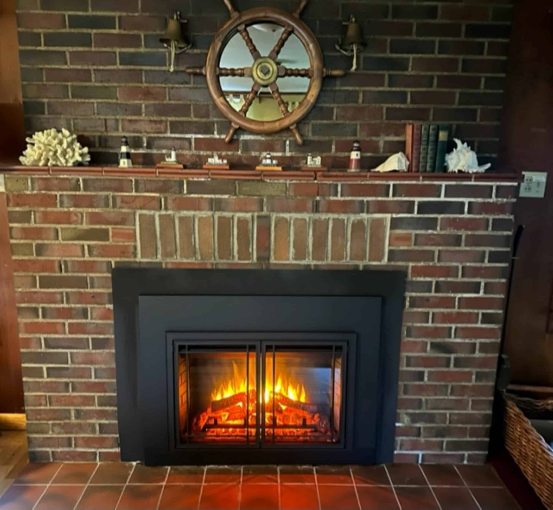 A brick fireplace with a ship steering wheel above it
