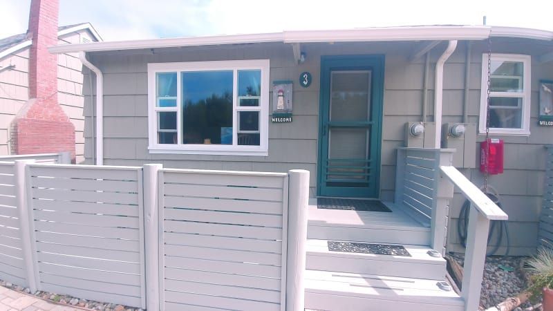 A small house with a white fence around it