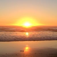 The sun is setting over the ocean and reflected in the water.