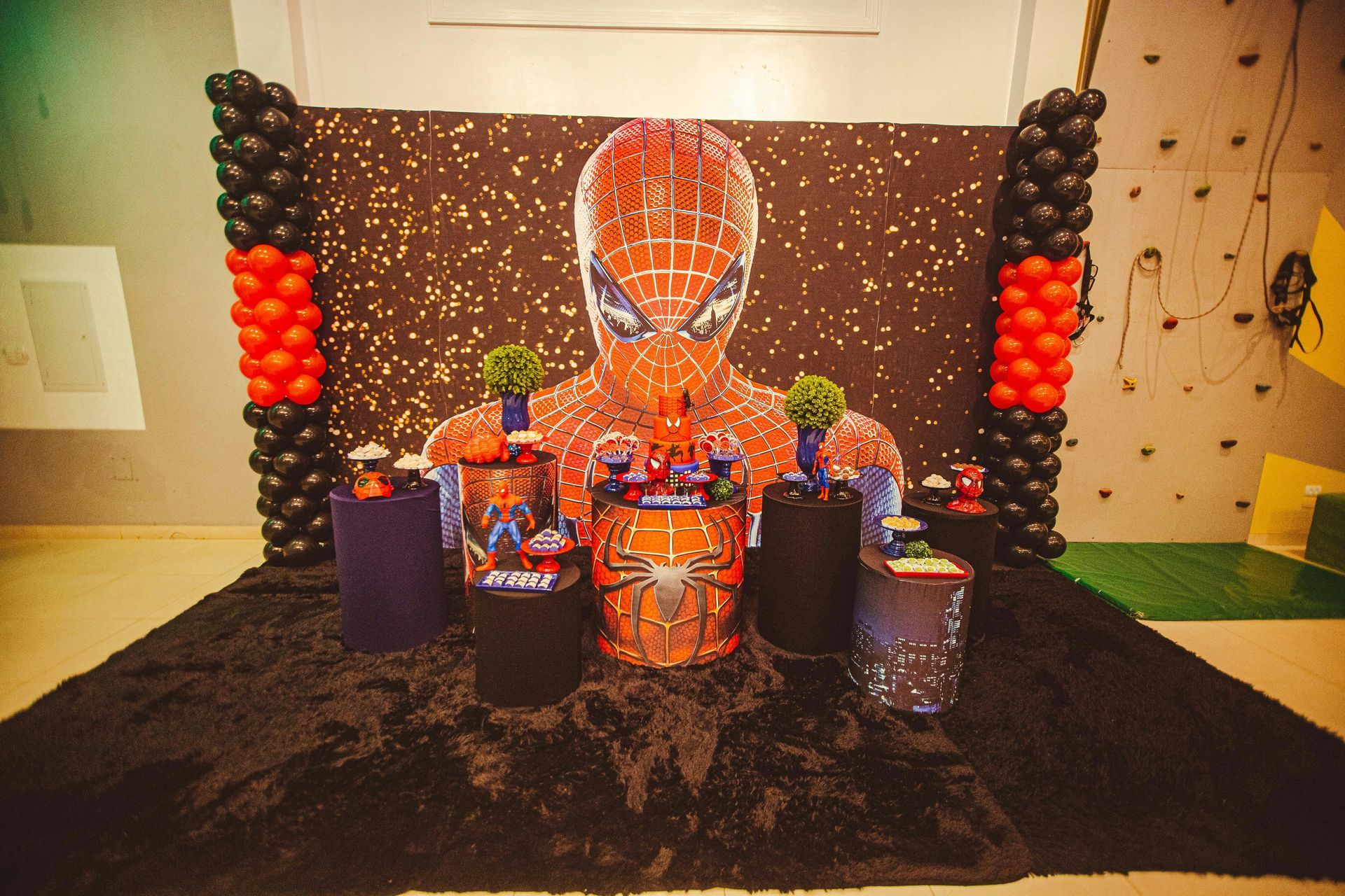 Spider-Man themed party decorations with a large Spider-Man figure, balloons, and treats on display.