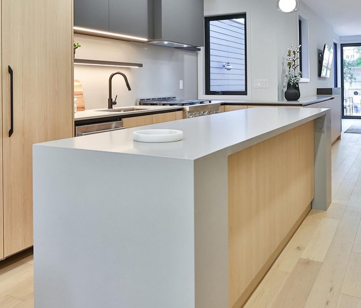 Quartz kitchen countertops and waterfall island in a chic, modern kitchen.