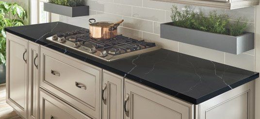 Rustic kitchen design with quartz countertops and wooden cabinetry.