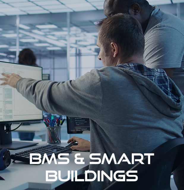 Two men looking at a computer screen with the words bms & smart buildings below them