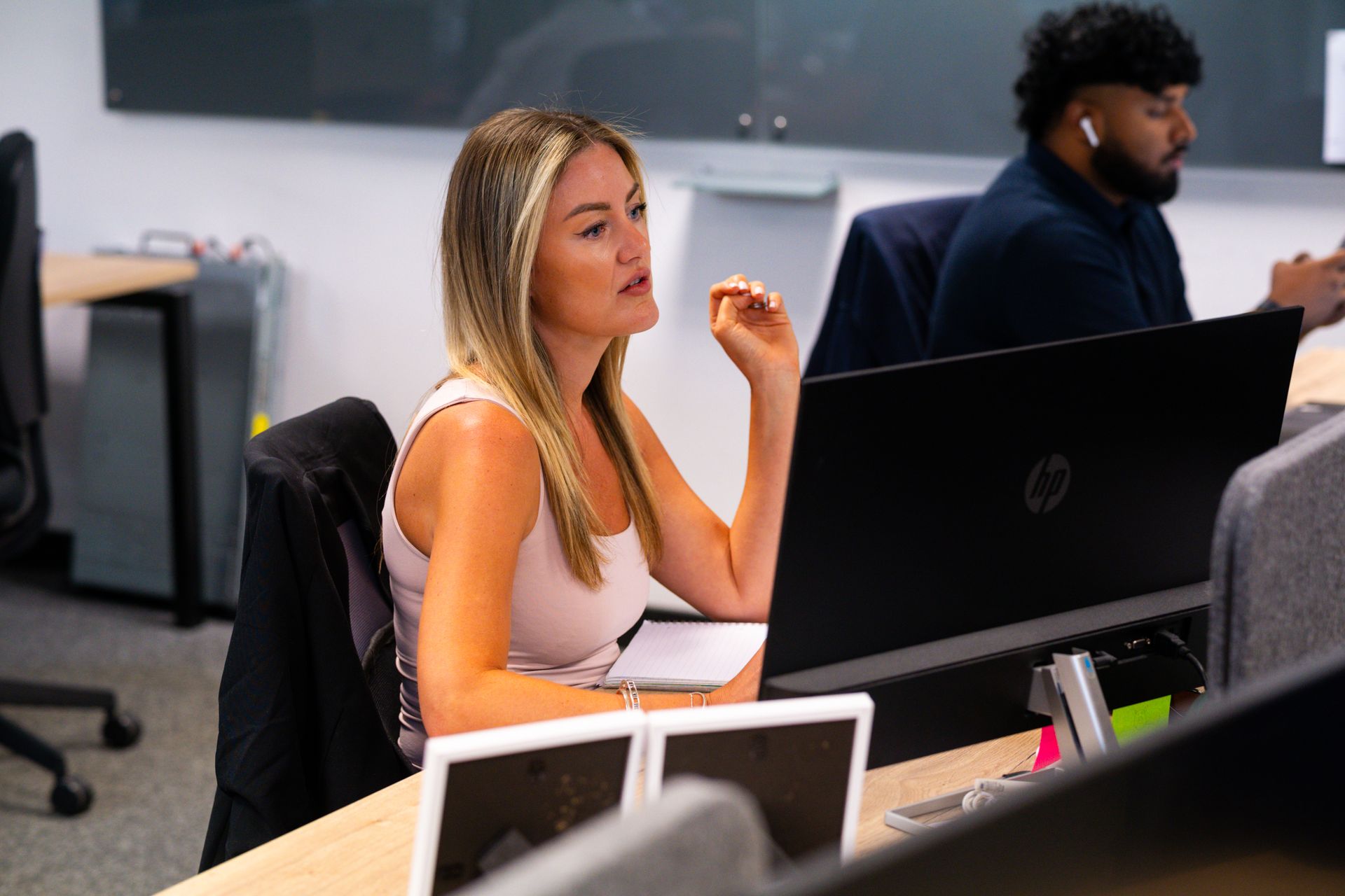 A woman is sitting at a table using a laptop computer.