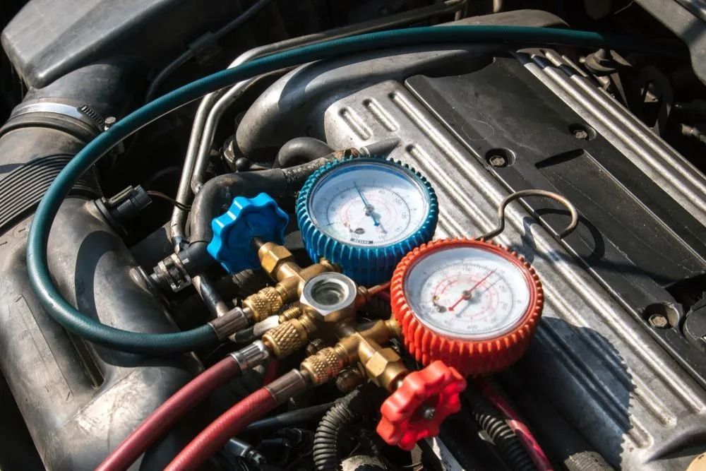 A Manifold Gauge Set With Red and Blue Dials Connected to Hoses — B & W Commercials In Kempsey, NSW
