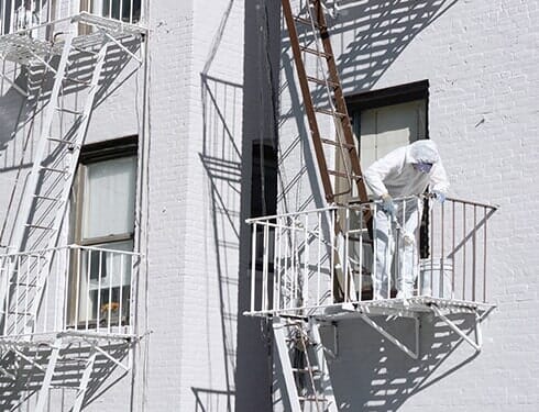 Building painter painting metal fire escapes - Fire Escape Services in Chicago, IL