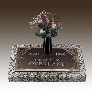 a gravestone for grace m. overland with a vase of flowers on it .