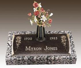 a gravestone for myron jones with a vase of flowers in it .