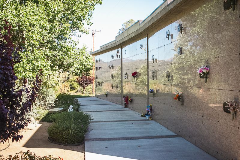 a cemetery with flowers on the walls and a walkway